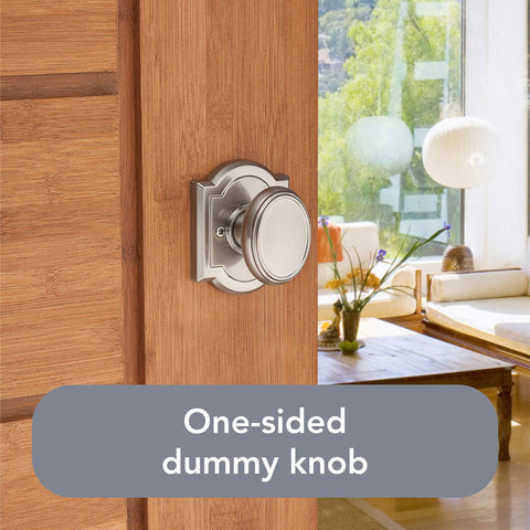 One-sided dummy knob in satin nickel on wooden door, living room in background