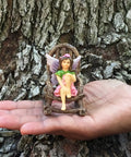 Rustic wood rocking chair from Three Piece Fairy Garden Furniture Set With Rustic Wood Bench, Rocking Chair And Mini Table For Your Garden Fairies Made From Resin, Built Tough For Indoor Or Outdoor Display And Totally Cute on a hand