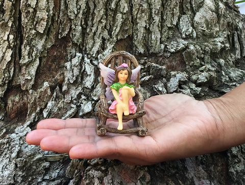 Rustic wood rocking chair from Three Piece Fairy Garden Furniture Set With Rustic Wood Bench, Rocking Chair And Mini Table For Your Garden Fairies Made From Resin, Built Tough For Indoor Or Outdoor Display And Totally Cute on a hand