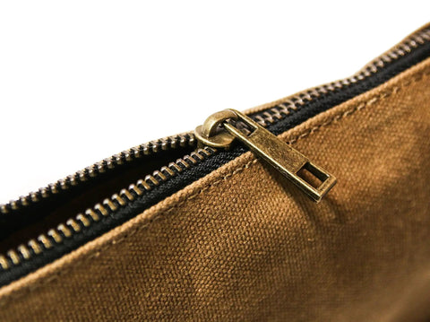 Close-up of a brass zipper on a tan waxed canvas zipper pouch from the Waxed Canvas Zipper Pouch Set, Heavy Duty Tool Organizer Bags.