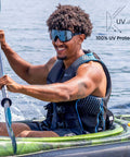 Person kayaking wearing Frameless Ultralight Black Mirror Swim Goggles With VisiClear Nanotech Anti Fog Lens And 100 Percent UV Protection