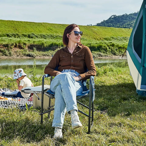 Woman sitting on Directors Chair For Outdoors With Side Table Foldable Camping Chair For Adults near a tent with scenic backdrop.