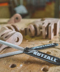 Pro Grade Heavy Duty Eight Inch Half Round Hand Rasp With Slick Ergonomic Soft Grip Handle And Tough Tungsten Carbide Coating on a woodworking table.