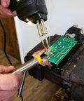 Fast Heat Soldering Gun Kit With Case And Rosin Core Solder, 2 Tips, 55 Inch Cord in use on electronic circuit board