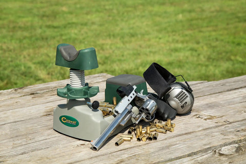 Pistolero Pistol Sight Adjustment Kit with 5 inch horizontal and 3 inch vertical travel on wooden table outdoors, pistol and ammo visible.