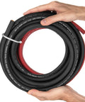 Hands holding coiled 1/0 Gauge Extra Flexible Welding Cable Set 10 Ft Black And Red Copper Pro Grade Industrial 600 Volt Welding Leads