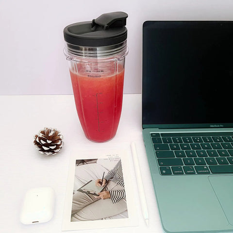 24 Oz cup with lid from 24 Oz Cups With Lids And 6 Fin Extractor Blade Replacement Kit For Nutri Ninja Auto IQ Blenders next to laptop