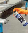 Hand holding aerosol can of Kick Rust To The Curb With These Premium Black Satin Aerosol Chassis Sprays built for cars and trucks.