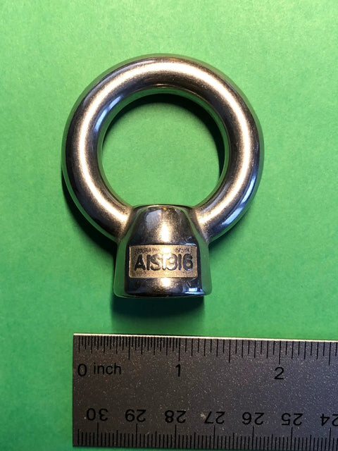 Tough As Nails Marine Grade Stainless Steel 316 M12 Lifting Eye Nut on green background with ruler for size reference.