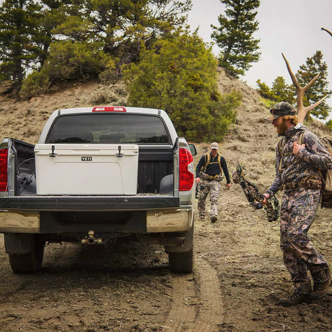 Rugged Rotomolded Outdoor Cooler With Three Inch Insulation And Bear Proof Certification in truck bed for hunting trip.