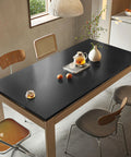 Refrigerator And Appliance Wrap Peel And Stick Wallpaper In Black Metallic Brushed Stainless Steel Look 15.7x78.7 inches on table.