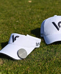 White golf cap and visor with GPS Golf Range Finder With Voice Yardage Output Auto Slope And Active Green Info on grass