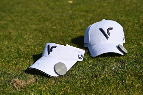 White golf cap and visor with GPS Golf Range Finder With Voice Yardage Output Auto Slope And Active Green Info on grass