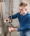 Man using Fast Acting Tubing Cutter 1/4 To 1-5/8 Inch For Copper, Brass, Aluminum And Plastic Tubing in a plumbing setting