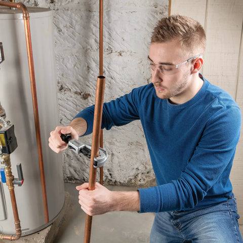 Man using Fast Acting Tubing Cutter 1/4 To 1-5/8 Inch For Copper, Brass, Aluminum And Plastic Tubing in a plumbing setting