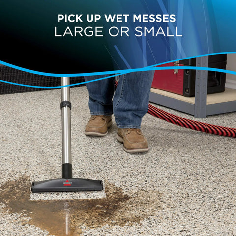 Hella Powerful Wet And Dry Garage Vacuum Featuring 11 Amp Motor And 6 Gallon Tank cleaning wet mess on garage floor with vacuum nozzle
