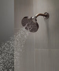 Oil Rubbed Bronze 5-Spray Shower Head With H2Okinetic Technology mounted on tiled wall, water spraying downwards