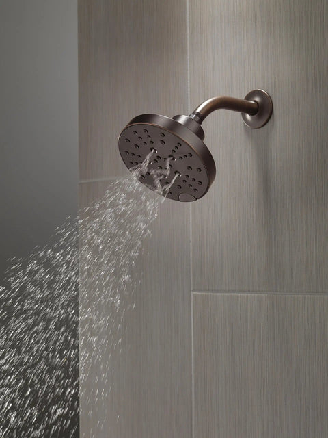 Oil Rubbed Bronze 5-Spray Shower Head With H2Okinetic Technology mounted on tiled wall, water spraying downwards
