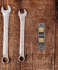 Heavy Duty Stainless Steel Sliding Door Wheels Featuring Double Bearing Pulleys and wrenches on wooden background.