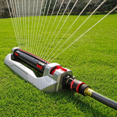 Heavy Duty Turbo Oscillating Sprinkler With 20 Precision Nozzles, aluminum base on green lawn, adjustable range visible