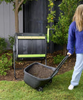 Woman using 48 Gallon Geared Dual Chamber Compost Tumbler with Large Fill Openings Elevated Design to fit compost cart