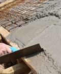 Worker using Pro-Grade Magnesium Concrete Float 3-1/8 x 16 In with beveled ends on wet concrete slab for smooth finish.