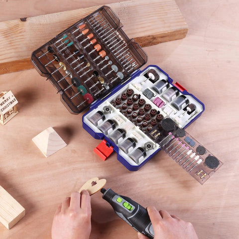 Open All In One 698 Piece Rotary Tool Accessories Kit with diamond cutting wheels, sanding bands, and flap discs on a wooden table.