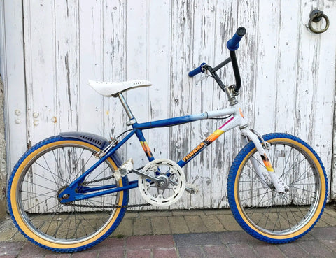 Swallow Shaped High Carbon BMX Handlebar 585mm Long With 22.2mm Clamp For Small Kid Bikes on colorful bike against wooden door