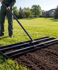 Person using 35 Inch Wide Lawn Leveling Rake With 6.5 Ft Long Handle, Heavy Duty Yard Leveler on dirt in a garden.