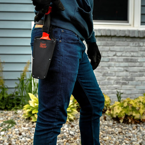 Person carrying All In One Garden Trowel With Holster For Digging Planting And Root Cutting Serrated Steel Blade Red Durable Comfortable Grip