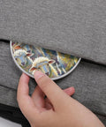 Hand placing 10W Fast Wireless Charger Pad Slim Portable Charging Station for Phone into a grey fabric bag pocket.