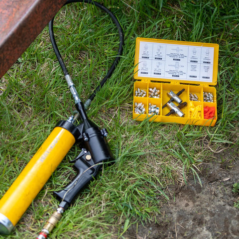 Grease fitting replacement kit with SAE/metric zerks in a yellow organizer case; includes assorted fittings and caps.