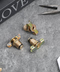 Three Pack Brass Air Compressor Drain Valve With Wing Nut Handle One Quarter Inch NPT Inlet on concrete surface