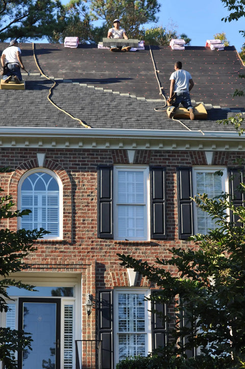Two roofers using Heavy Duty Roofing Cushion With Killer Traction And Heat Blocking Kneeler Mat on steep shingle roof.