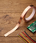 Straight Up Pure Copper Welding Strips For Ev Battery Packs And Power Modules Smooth Thin Copper Metal Roll on wooden table.