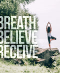 Person doing yoga pose on rocks overlooking water with 'Breath Believe Receive' text overlay.