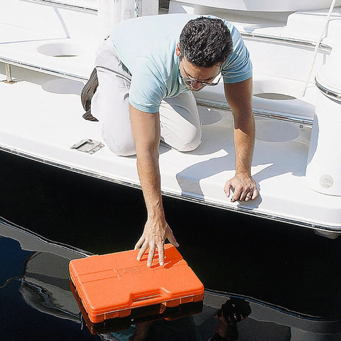 Man retrieving 125 Piece Marine Tool Set in a Water Resistant Boat Tool Box from water, orange case floating