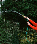 Person using a garden hose with Two Pack Heavy Duty Brass Hose Nozzles With Two Shutoff Valves High Pressure Jet Nozzles.