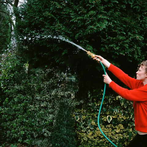 Person using a garden hose with Two Pack Heavy Duty Brass Hose Nozzles With Two Shutoff Valves High Pressure Jet Nozzles.
