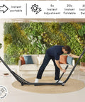 Person setting up hammock with heavy duty steel stand for indoor and outdoor chill sessions 600lb capacity foldable 2 layer soft polyester