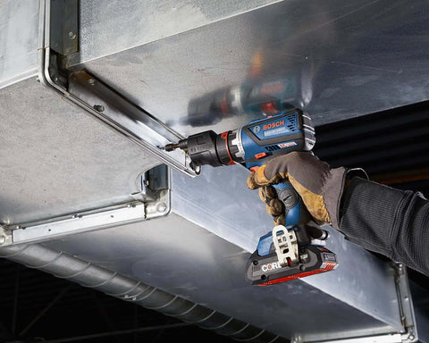 Compact 18V Cordless Drill Driver With Brushless Motor And Rugged Locking Chuck Supporting 5In1 Flexiclick Quick Swap System Paired With A Badass 4Ah Battery Pack being used to secure metal ductwork.