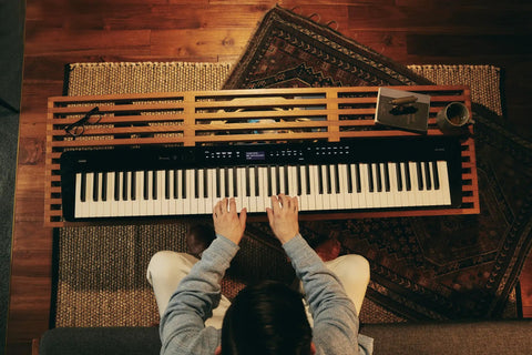 Px-S3100 88 Key Weighted Digital Piano With Bluetooth Audio MIDI on wooden stand, player seated, seen from above