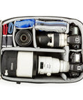 Interior of Airport Accelerator Camera Backpack for Travel Photographers Fits Two Gripped DSLRs With 600mm F4 Or 500mm F4 Attached 17 Inch Laptop and 10 Inch Tablet Built For Carry On Convenience And Everyday Rugged Use, showing organized compartments with lenses.
