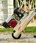 Person carrying 135 Psi 5.5 Hp Gas Powered Air Compressor with Honda engine and wheelbarrow design on gravel.