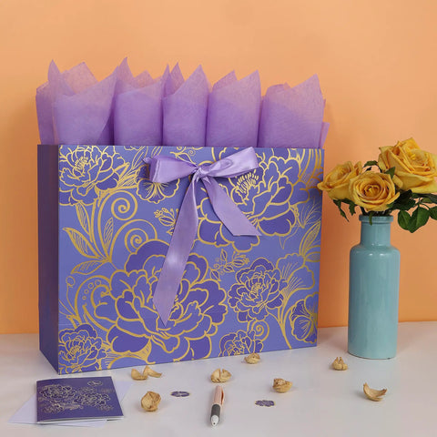 Extra Large 16.5 Inch Rose Purple Gift Bag Set With Greeting Card And Tissue Paper For Birthdays Mothers Day Weddings And Anniversaries With Gold Foil Accents And Delicate Rose Floral Design For A Boss Gift Experience, displayed with purple tissue paper and yellow flowers in vase.