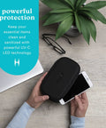 Person using UVC Portable Sanitizer Box With Rechargeable Battery Kills Ninety Nine Point Nine Percent Germs On The Go Fits Masks Makeup Brushes Glasses Phones Keys Black on a smartphone with accessories nearby.