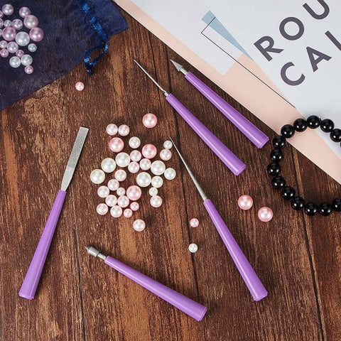 Front view of Mudder bead reamer set with 10 purple-handled, diamond-tipped tools beside pink and white beads on a wooden surface