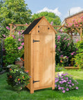 Front view of Outdoor Wooden Storage Shed With Safety Latch Teak Finish Durable Garden Tool Cabinet in a lush garden setting.