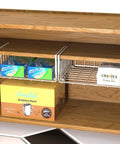 Hella Versatile Two Pack Under Shelf Wire Baskets White Metal Drop Down Organizers holding snacks and tea in kitchen pantry.