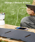 Solix PS30 Foldable 30W Solar Panel Charger charging devices outdoors on a wooden table, demonstrating dual USB-A and USB-C ports.